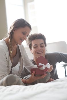 Beautiful young woman opening present from her boyfriend 