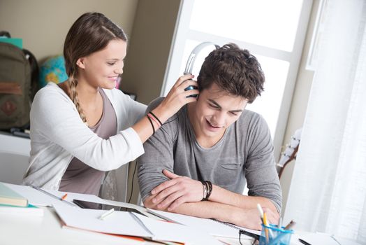 Teen boy and girl sitting together and studying 