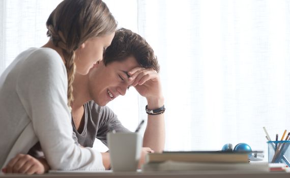 Teen boy and girl sitting together and studying 