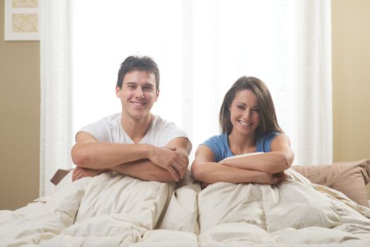 Portrait of a happy young couple lying on bed