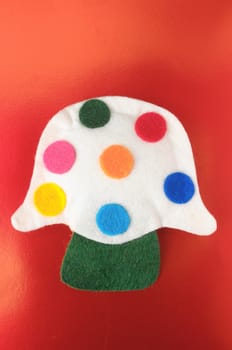 Cloth Multicolored Magic Mushroom on a Colored Background