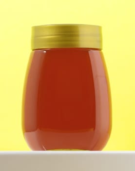 One Full Honey Jar on a Colored Background