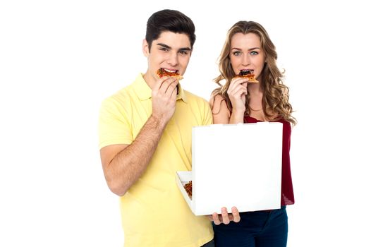 Young couple relishing yummy pizza