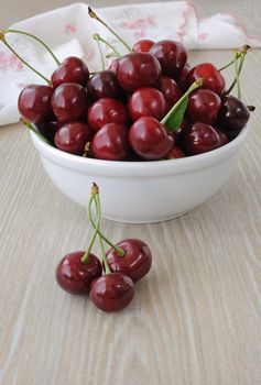 plate of ripe cherries on the table with a napkin
