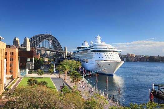 Sydney, Australia - December 1, 2013;  Royal Carribean Cruise Liner, Radiance of the Seas docked at Circular Quay in Sydney.   Sydney Harbour Bridge in background.  This ship boasts floor to ceiling windows throughout and outdoor cinema playing first run movies.  Motion blur in people