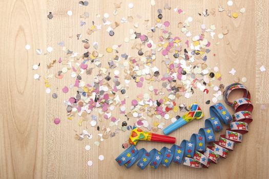 streamers and confetti as decoration for parties, sylvester with wooden background