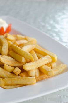 a pile of appetizing french fries on white plate