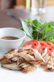 slice grilled pork  served with fresh vegetable on white dish