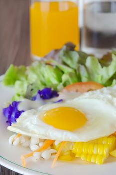 close up fried egg and fresh vegetable  salad on dish