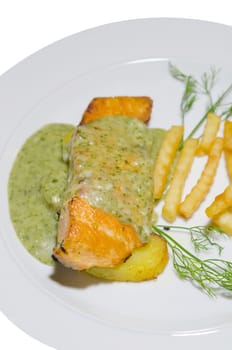 roasted salmon served with green sauce and french fries  on white plate