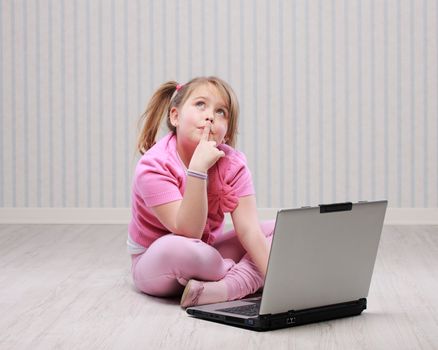 Cute little girl working on a notebook computer