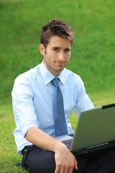 Young business man working on laptop outdoors