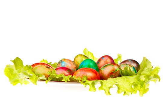 Easter eggs on a plate with green leaves