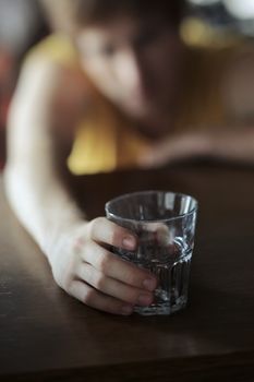 Drunk boy on a bar table holding an empty glass