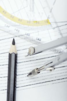 Scheme with drawing tools. Extremely close-up photo. Focus on the compasses