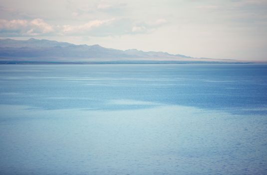 View on the cold lake with mountains on a background
