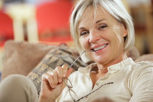 Portrait of a smiling senior woman sitting on couch
