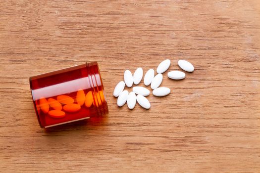 white pill with bottle on wooden plate