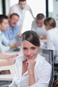 Portrait of a pretty young executive with her team in the background 