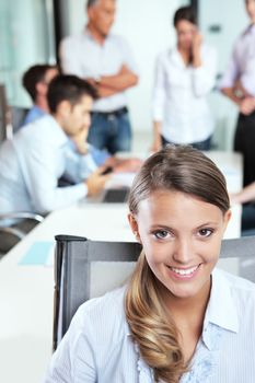 Portrait of a pretty young businesswoman with her team in the background 