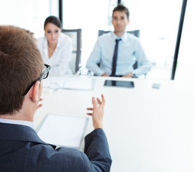 Two business people having job interview with young man