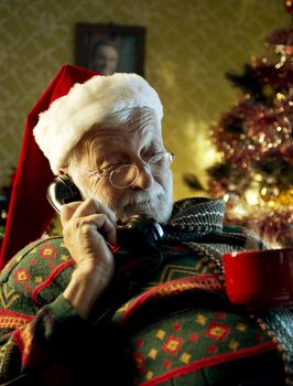 Pictures of Santa Claus relaxing at home and talking on phone