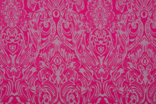 Silver flowers on a pink textil background.