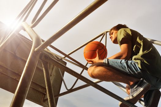 Boy with a basketball waiting his friends for a match