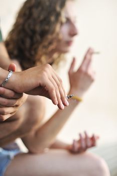 Cropped shot of two teenagers smoking cigarettes 