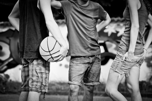 Group of friends talking and taking a break after playing basketball