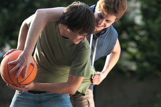 Boys playing a game of basketball on an outdoor court.