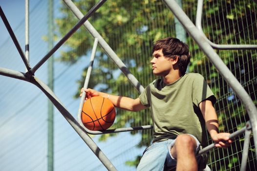 Boy with a basketball waiting his friends for a match