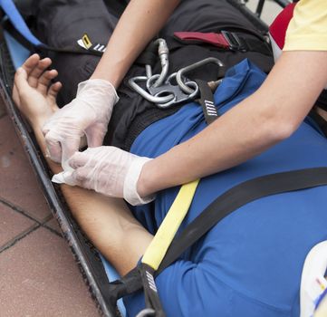 Paramedics putting a bandage on an injured hand