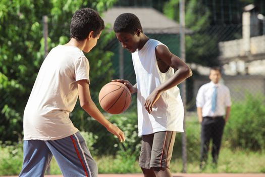 Two young African boy play basketball outdoors