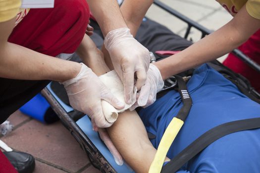 Paramedics putting a bandage on an injured hand