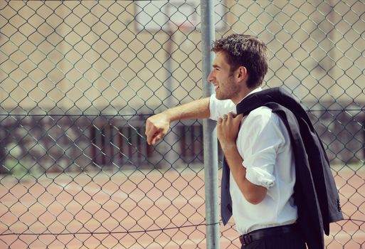 Young Business man looking away, basketball court on background