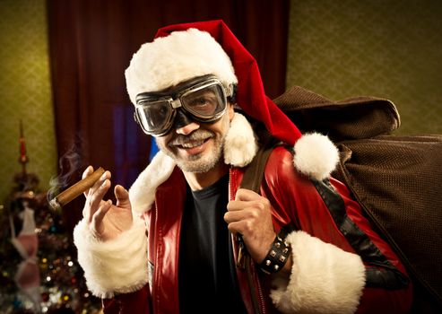 Bad Santa with gift bag smoking cigar and smiling at camera