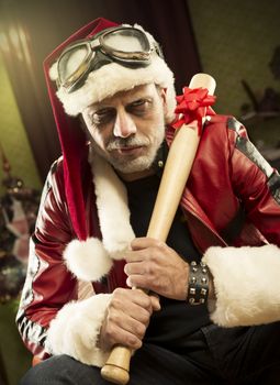 A frowning Bad Santa with baseball bat looking at camera