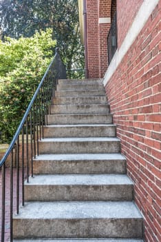 cement stairs next to brick wall with metal railing