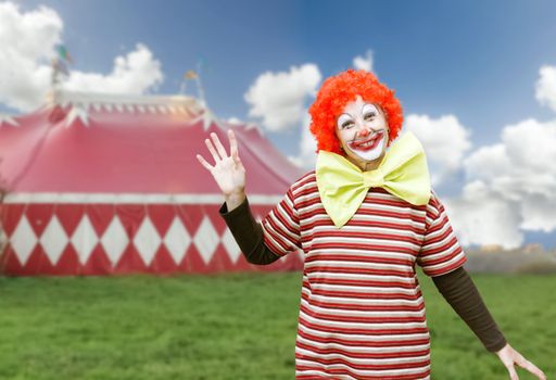 Funny girl clown with big bow tie and makeup over circus tent background