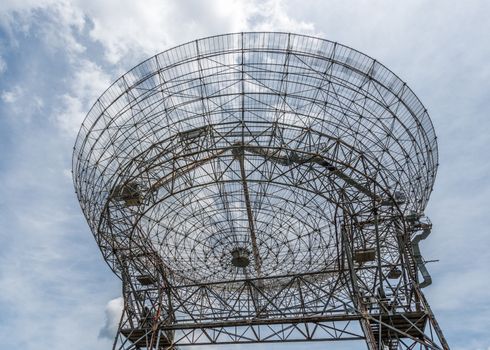 Base of a large astronomy radar with sky as background 