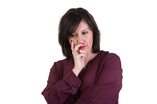 Middle Aged Businesswoman in shirt looking down thoughtfully with her hand on her face