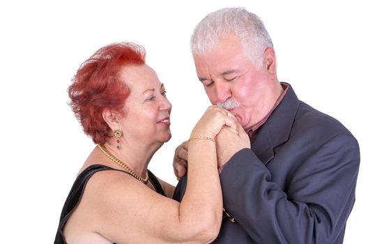 Senior man kissing his wifes hand, both looks happy, perhaps its their anniversary