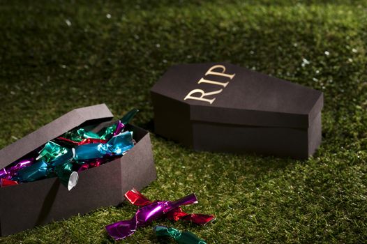 Halloween coffin on lawn with sweets and candies