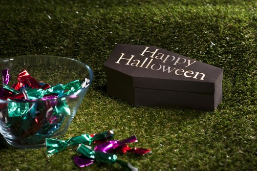 Halloween coffin on lawn with sweets and candies