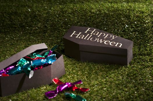 Halloween coffin on lawn with sweets and candies