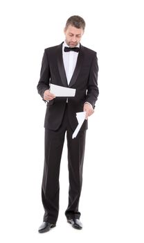 Stylish middle-aged man in a bow tie and tuxedo reading the document in his hand