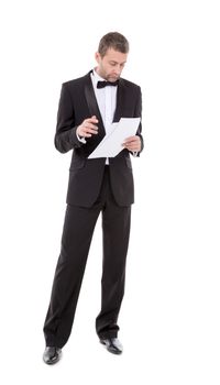 Stylish middle-aged man in a bow tie and tuxedo reading the document in his hand
