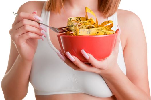 Woman eating a bowl of measruring tapes. Diet concept.