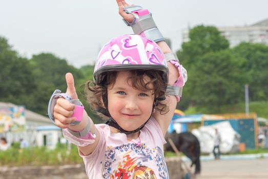 Portrait of the child in the open air on roller skates in a protective helmet